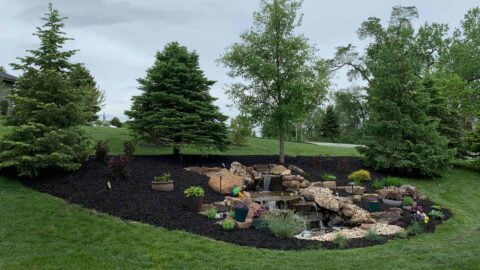 Outdoor Multi Level Water Feature Surrounded By Rocks Mulch Trees